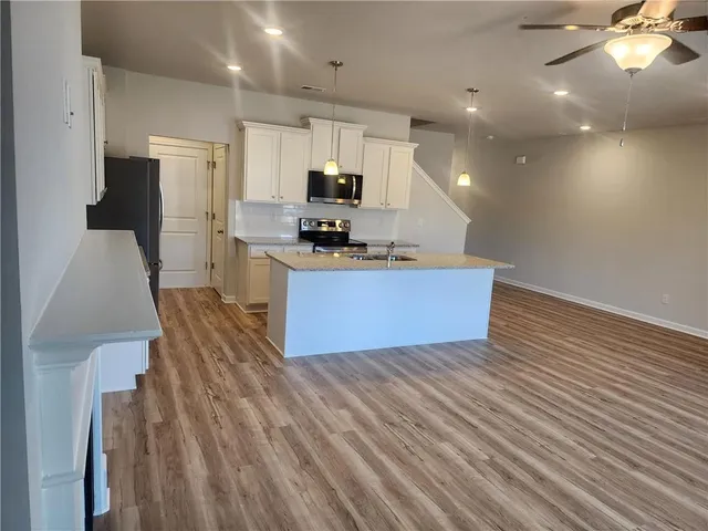 a kitchen with stainless steel appliances a refrigerator sink and microwave