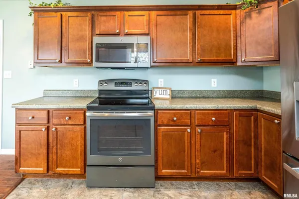 a kitchen with granite countertop wooden cabinets and a stove top oven