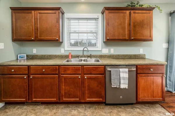 a kitchen with stainless steel appliances granite countertop wooden cabinets a sink and dishwasher