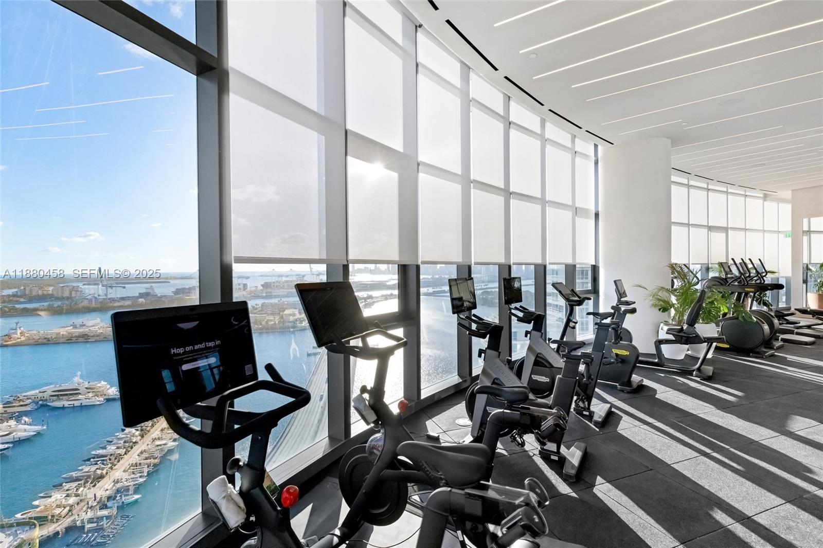 500 Alton Road, Unit 2802 Miami Beach, FL 33139 - Photo 45 of 51 a view of a workspace with furniture and floor to ceiling window