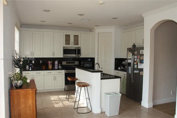 a kitchen with stainless steel appliances kitchen island granite countertop a refrigerator and stove