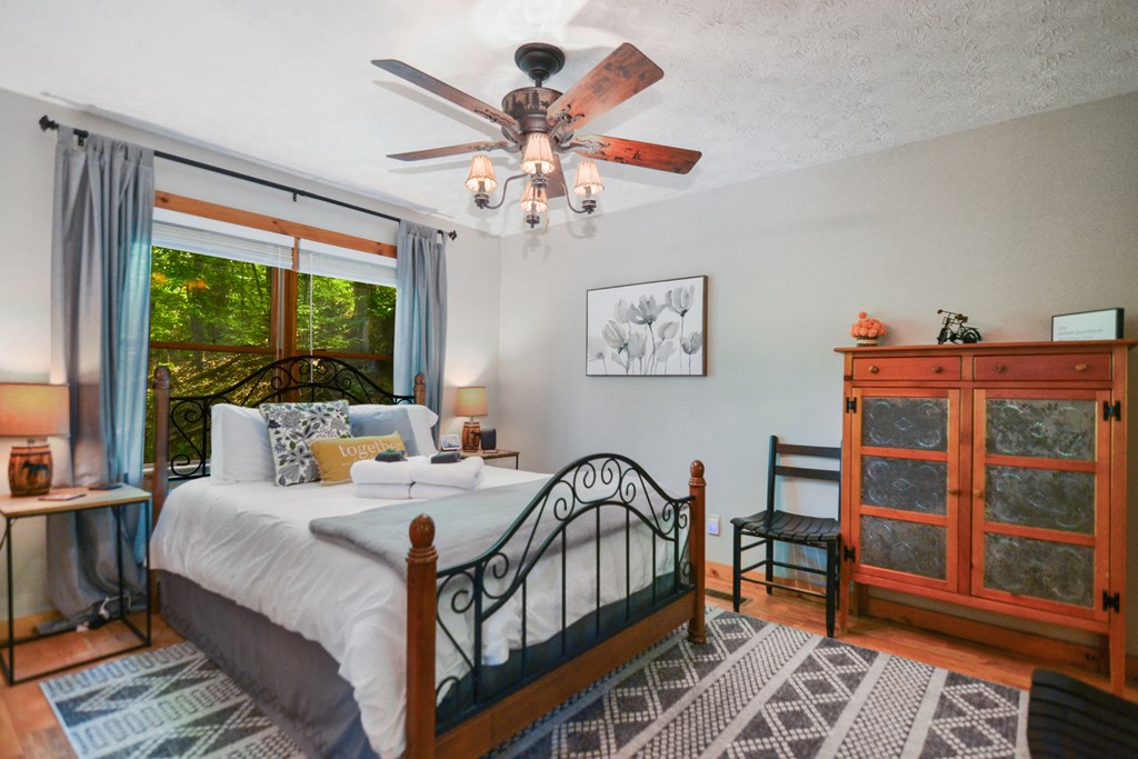 1213 Mountain Oak Road Ellijay, GA 30536 - Photo 15 of 65 a bedroom with furniture a chandelier and a large window