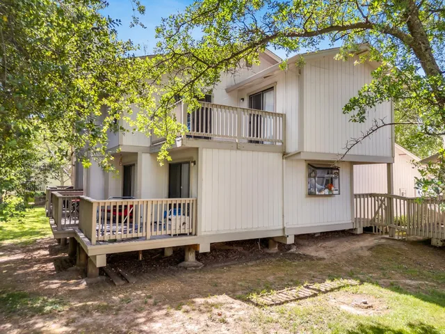 a view of a house with a wooden deck and a patio