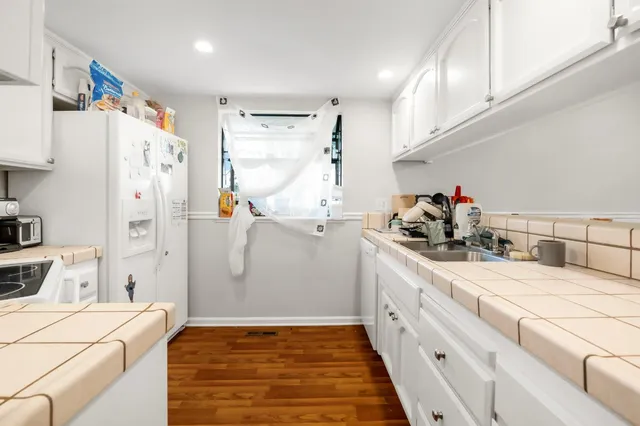 a kitchen with white cabinets and refrigerator