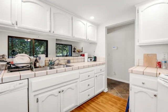 a kitchen with granite countertop a sink stainless steel appliances and cabinets