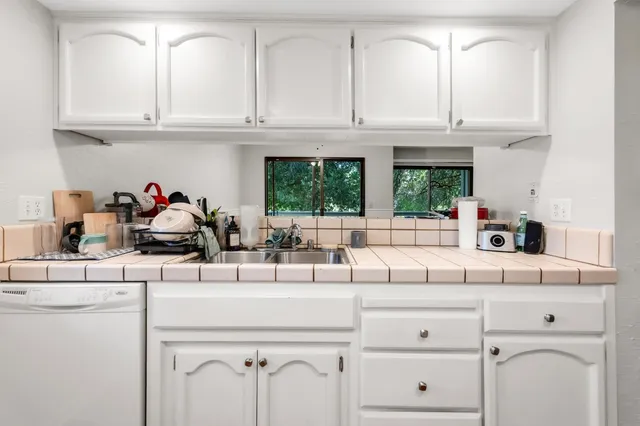 a kitchen with white cabinets and a sink