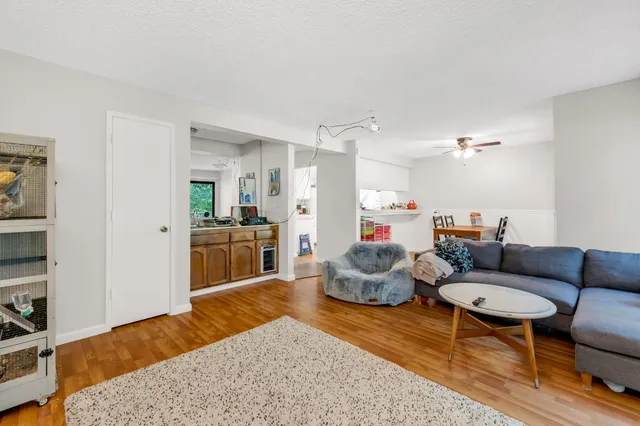 a living room with furniture a rug and kitchen view