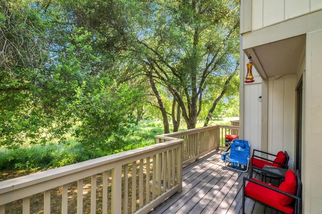 a view of deck with furniture and trees