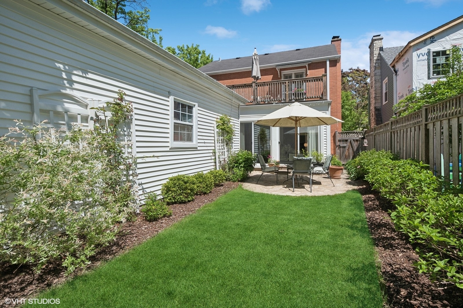 2044 Ewing Avenue Evanston, IL 60201 - Photo 29 of 35 a patio with table and chairs with plants and wooden fence