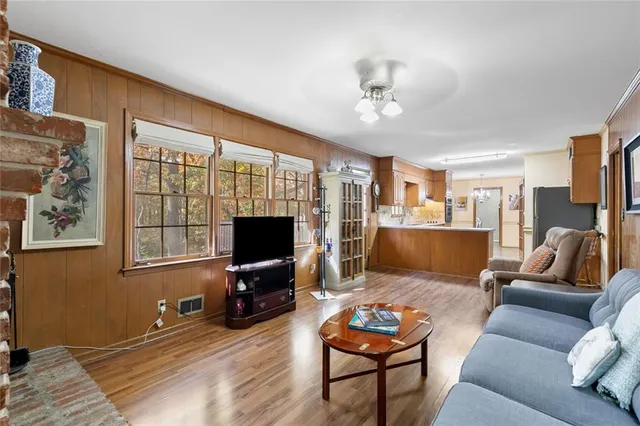 a living room with furniture a flat screen tv and a window