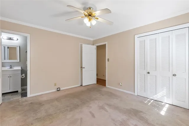 an empty room with closet and a chandelier fan