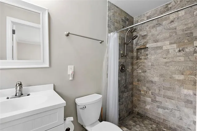 a bathroom with a sink a toilet and shower