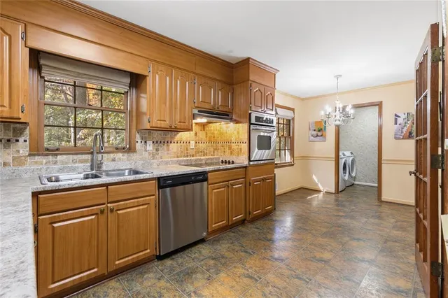 a large kitchen with granite countertop a sink and cabinets