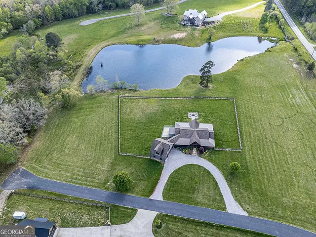 a view of a small house with a big yard and large trees