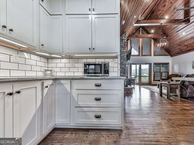 a kitchen with granite countertop white cabinets and white appliances
