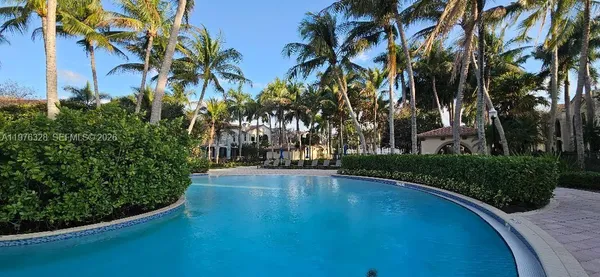 a view of a house with a yard and palm trees