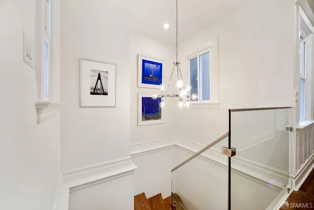 a bedroom with a large bed and painting on the wall