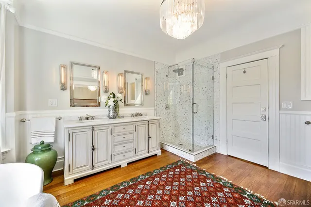 a bedroom with a bed a table and large windows