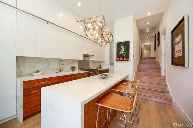 a living room with furniture kitchen view and a window
