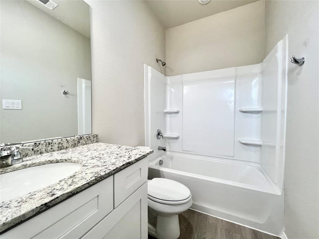 3501 East Renfro Street, Unit 120 Burleson, TX 76028 - Photo 17 of 30 a bathroom with a granite countertop sink a toilet and shower