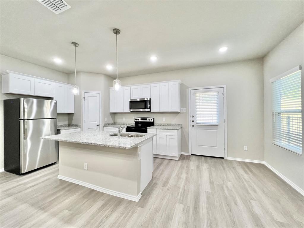 3501 East Renfro Street, Unit 120 Burleson, TX 76028 - Photo 5 of 30 a kitchen with white cabinets and stainless steel appliances