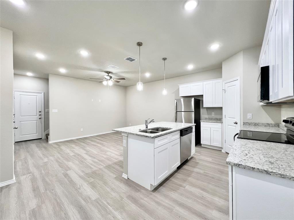 3501 East Renfro Street, Unit 120 Burleson, TX 76028 - Photo 9 of 30 a kitchen with granite countertop a sink and a stove top oven