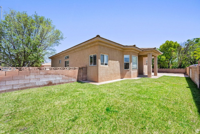 2226 East 140 South St. George, UT 84790 - Photo 19 of 20 Expansive green lawn with a stucco exterior home