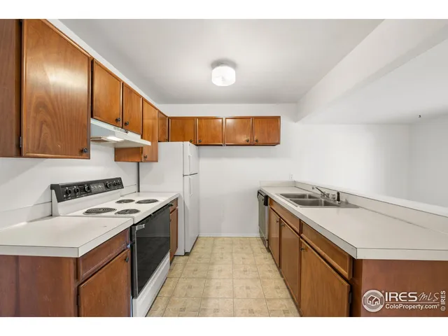 a kitchen with granite countertop a sink stove and cabinets