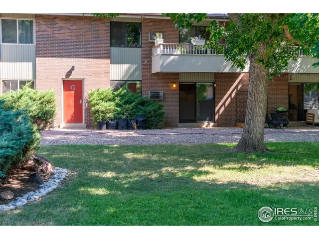 a view of a house with a yard and potted plants