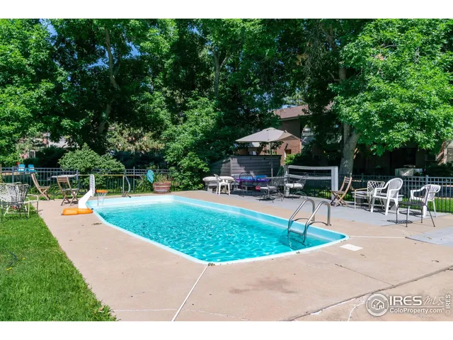 a view of a swimming pool with sitting area and furniture