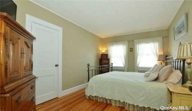 31 Highland Court Huntington, NY 11743 - Photo 5 of 12 a bedroom with a bed and wooden floor