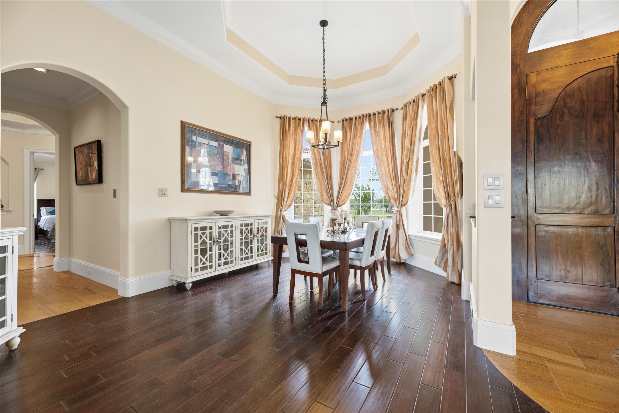 6306 Farm To Market 359 Fulshear, TX 77441 - Photo 10 of 44 Located directly off the foyer, this sophisticated dining area features an elegant tray ceiling and crown molding, providing seamless access to the gourmet kitchen and butler’s pantry.