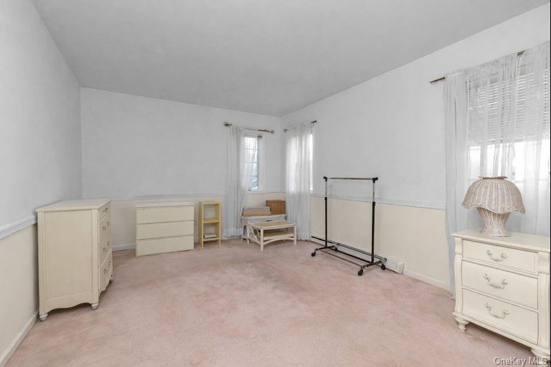 39 Fleets Cove Road Huntington, NY 11743 - Photo 15 of 20 Living area with light carpet and a baseboard radiator