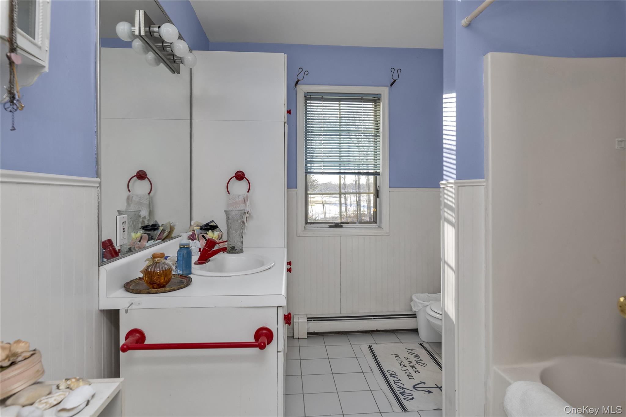 39 Fleets Cove Road Huntington, NY 11743 - Photo 17 of 20 Full bath with a wainscoted wall, vanity, light tile patterned floors, baseboard heating, and a bathtub