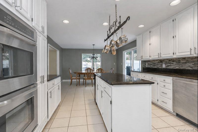 39 Fleets Cove Road Huntington, NY 11743 - Photo 5 of 20 Kitchen featuring stainless steel appliances, white cabinets, recessed lighting, dark stone counters, and a kitchen island