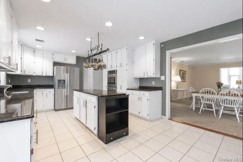 39 Fleets Cove Road Huntington, NY 11743 - Photo 6 of 20 Kitchen with open shelves, a kitchen island, appliances with stainless steel finishes, white cabinets, and recessed lighting