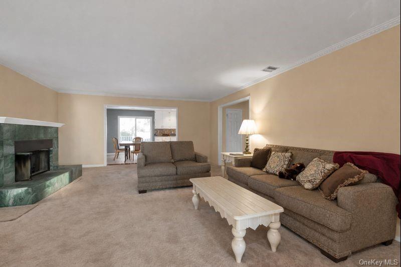39 Fleets Cove Road Huntington, NY 11743 - Photo 8 of 20 Living area with carpet, crown molding, and a tile fireplace