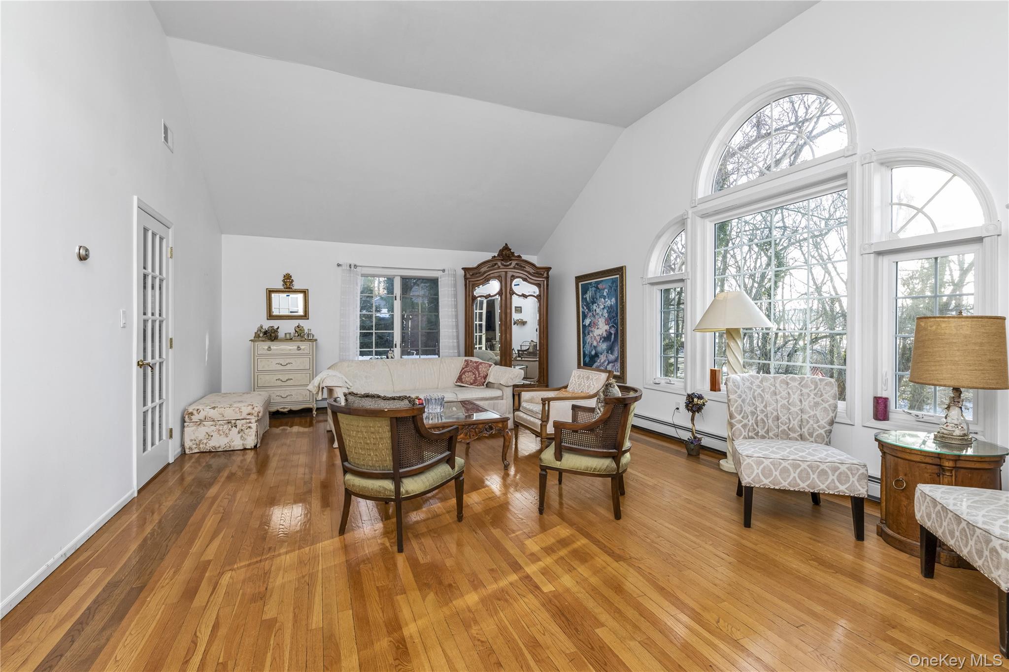 39 Fleets Cove Road Huntington, NY 11743 - Photo 10 of 20 Living room featuring high vaulted ceiling, wood-type flooring, and baseboard heating
