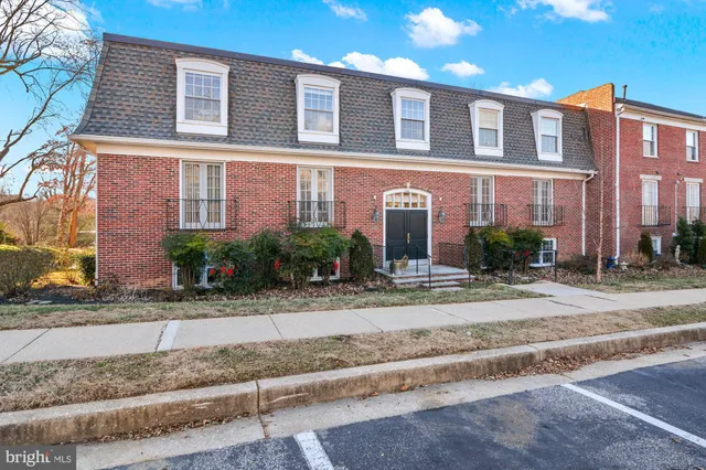 a view of a brick house many windows and plants