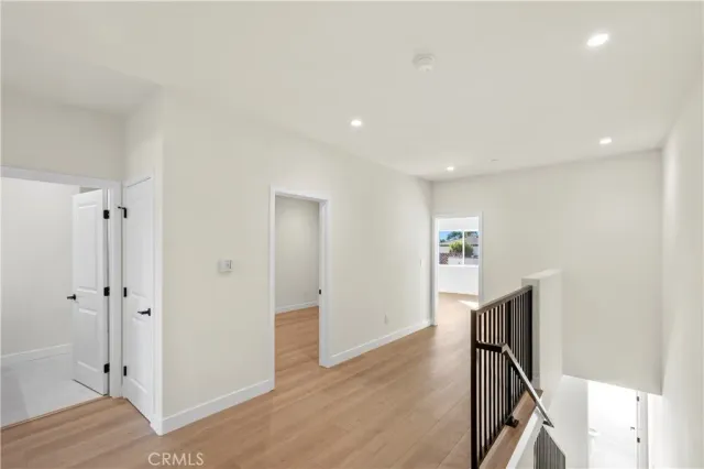 a view of a hallway with wooden floor and staircase