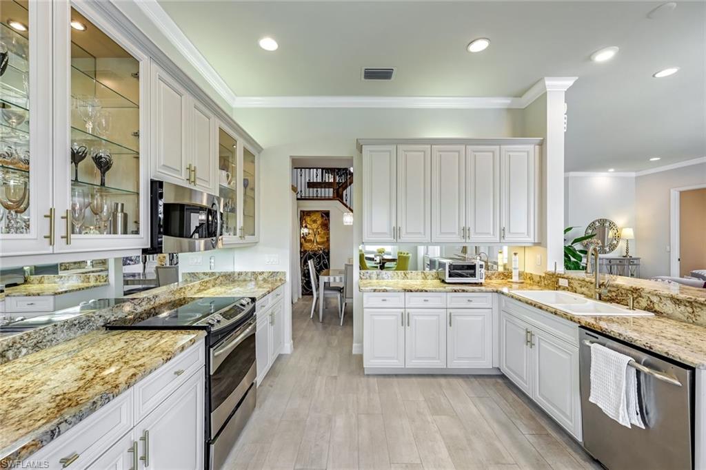 6582 Monterey Point Naples, FL 34105 - Photo 8 of 27 a kitchen with stainless steel appliances granite countertop a sink stove and refrigerator