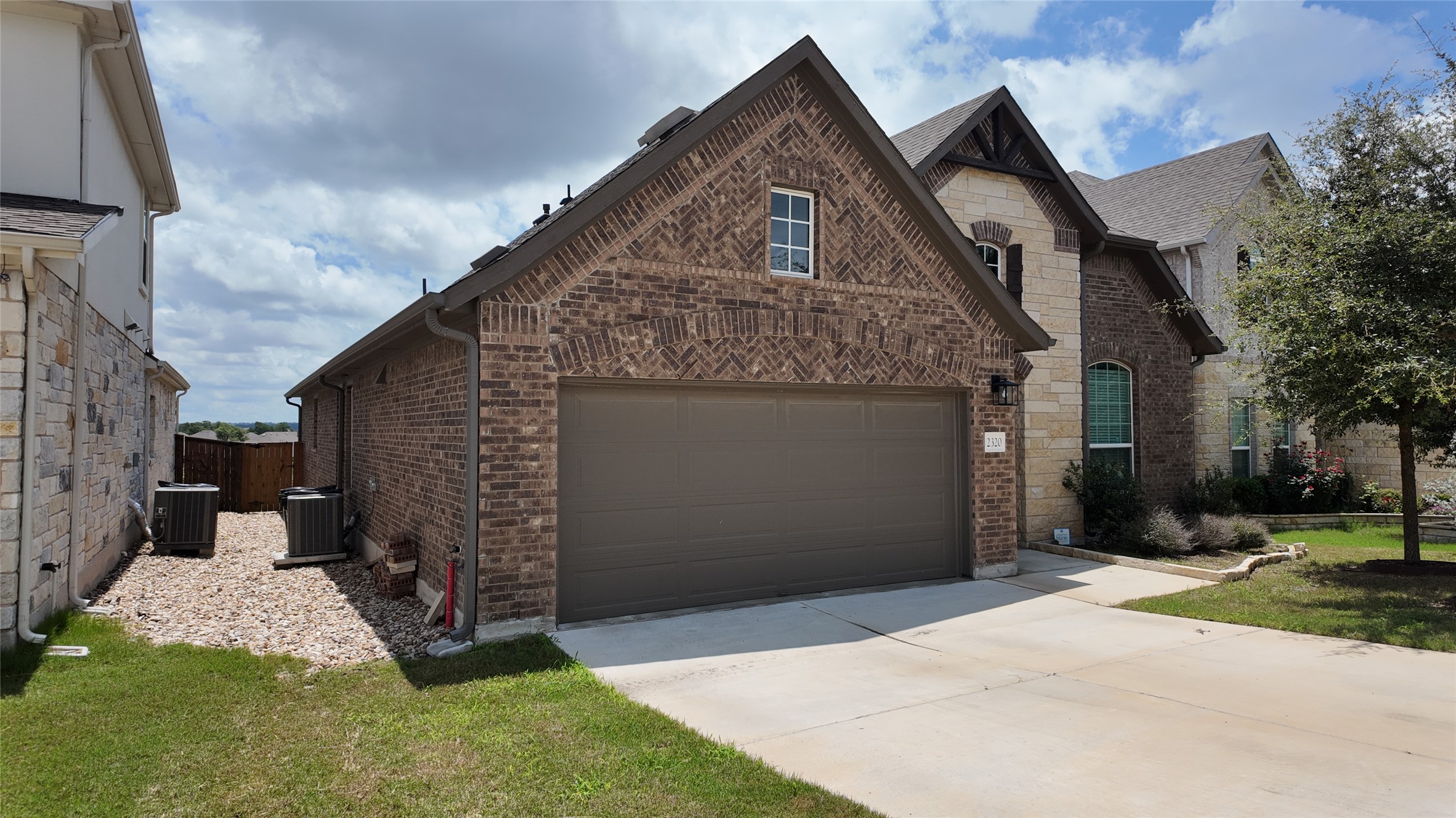 2320 Base Burner Path Leander, TX 78641 - Photo 2 of 24 Brick and stone accents adorn this charming front exterior, featuring a double garage and landscaped entry.