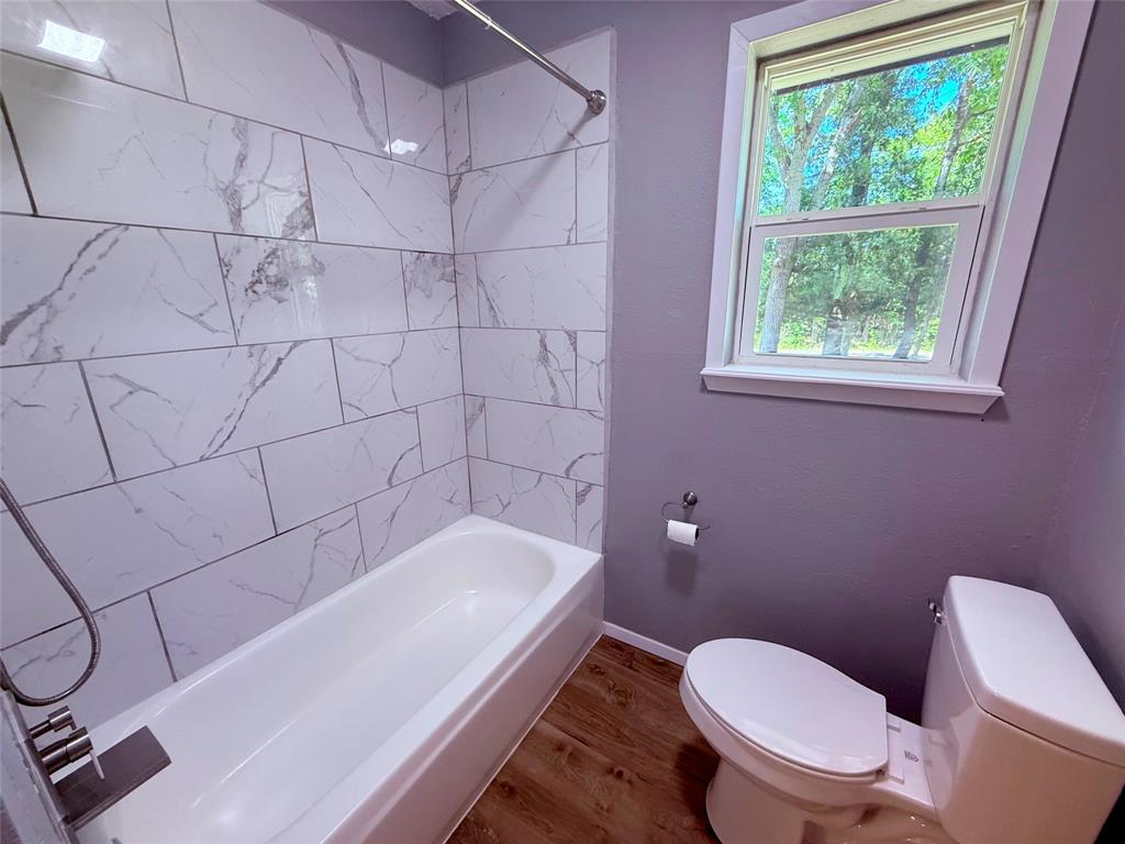 45 County Road 1197 Yantis, TX 75497 - Photo 18 of 26 a bath tub sitting next to a white toilet and a shower