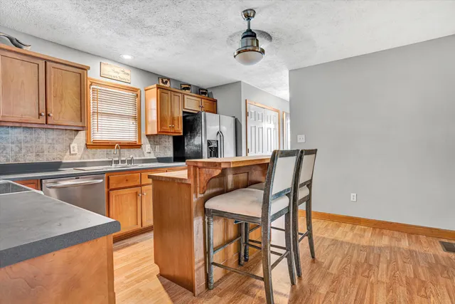 a kitchen with stainless steel appliances granite countertop a stove a sink dishwasher and a microwave oven with cabinets