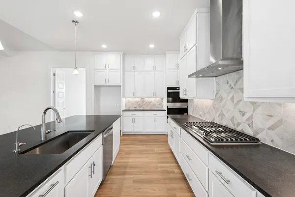 a large kitchen with stainless steel appliances granite countertop a sink stove and refrigerator