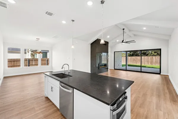 a kitchen with granite countertop a stove and a wooden floors