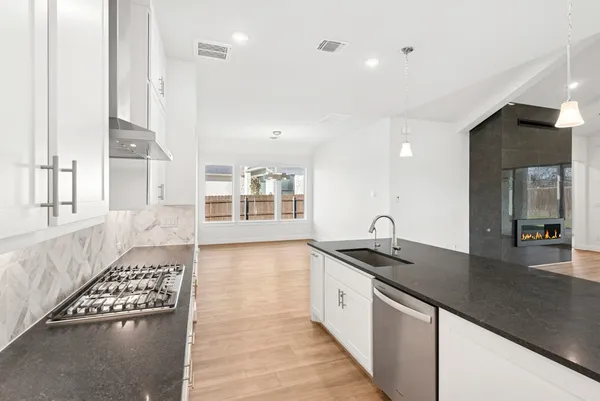 a kitchen with granite countertop a sink stove and cabinets