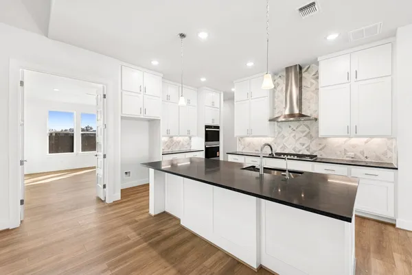 a large kitchen with granite countertop a large counter top appliances and cabinets