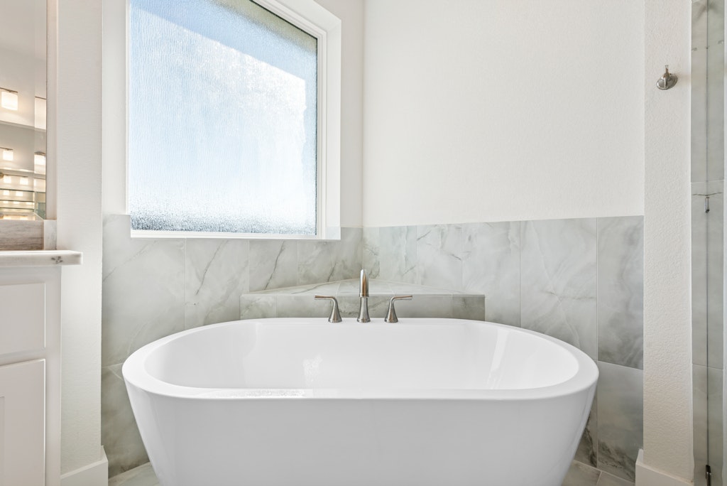 3332 Emerald Lake Path Georgetown, TX 78628 - Photo 22 of 35 a white bath tub sitting in a bathroom