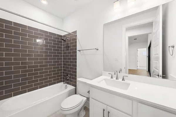 a bathroom with a sink a toilet a mirror a bathtub and shower